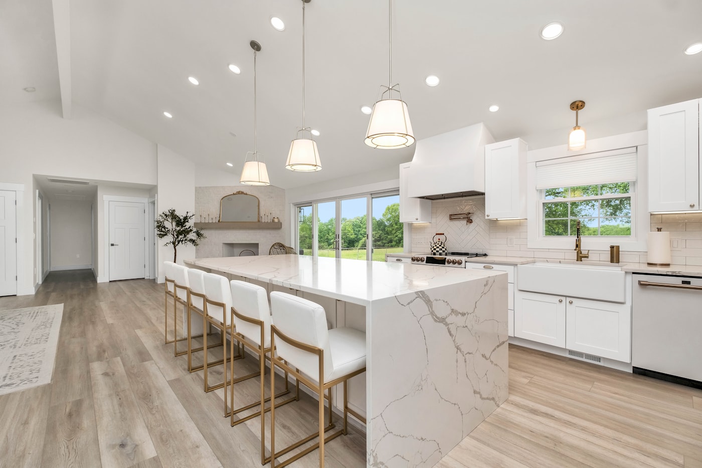 Marble kitchen island styled with white cabinetry, a study in warm minimalist interiors